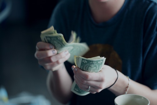 person counting out cash 