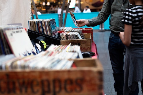 person flicking through records at garage sale