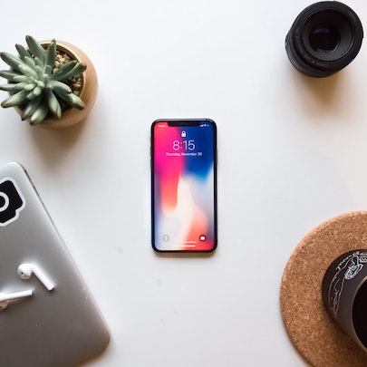 iPhone on white table and plant